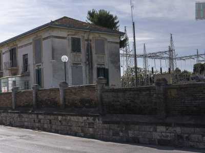 Proprio accanto a questo stabilimento si trova una villetta antica a due piani. Nonostante sia disabitata e trascurata (qualche finestra � addirittura murata), mantiene una certa particolarit� data dal tetto spiovente, dalle persiane verdi e da una vetrata che fa da cornice alla porta d�ingresso. Difficile non percepire l�evidente contrasto tra questo edificio e i tralicci che lo affiancano